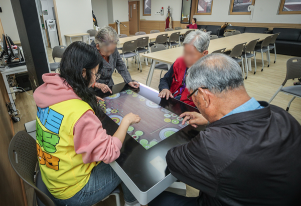 스마트 경로당에서 동행단과 스마트테이블을 이용해 게임을 즐기는 어르신들의 모습./사진=서울시